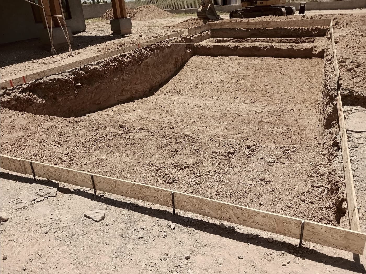 Footing trenches cut and squared, ready for steel.