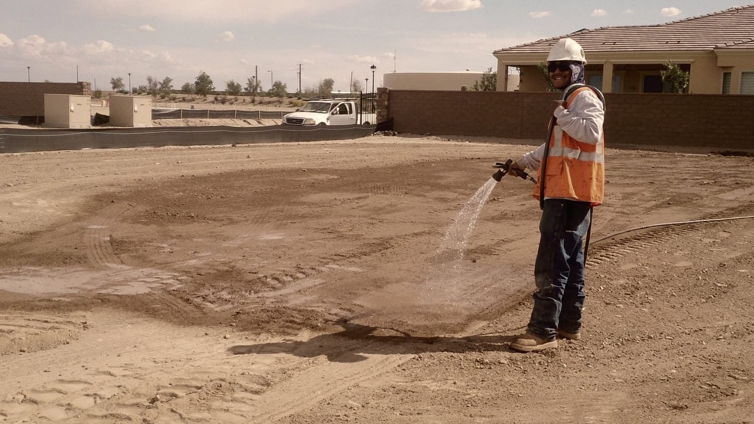 Watering down a finished pad before the compactor goes over it.